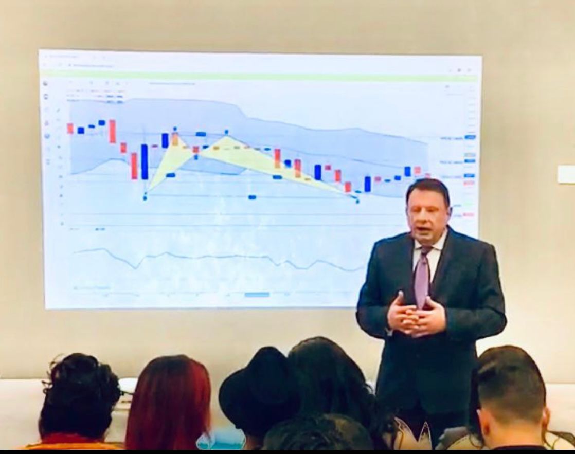 Ivan presenting in front of a market chart