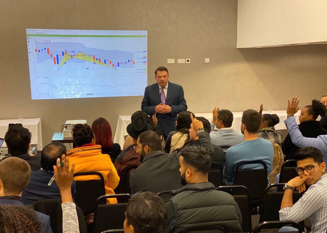 Ivan Smith explaining a foreign exchange chart to a classroom of students
